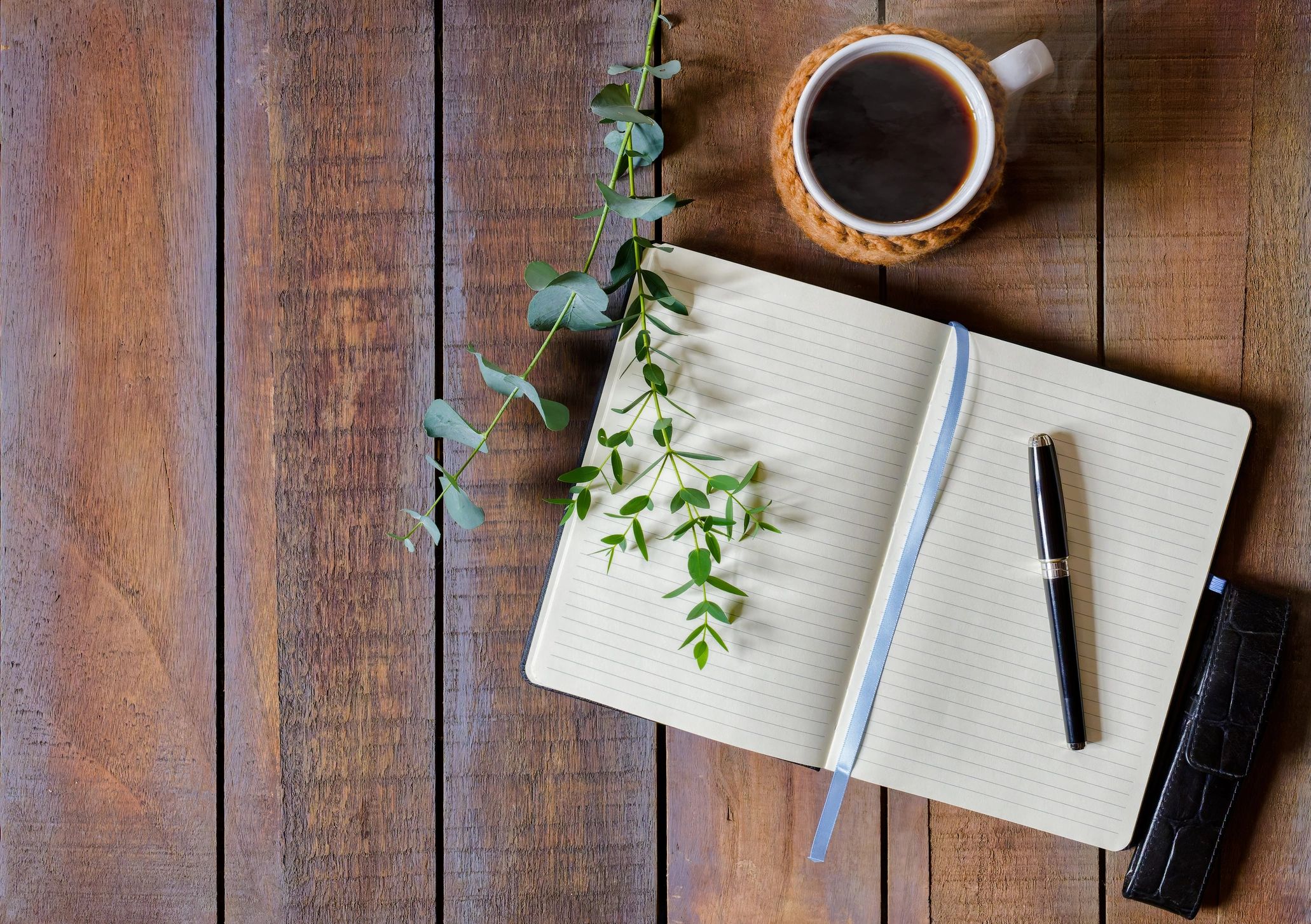 Open journal and coffee on a wooden table, calm workspace